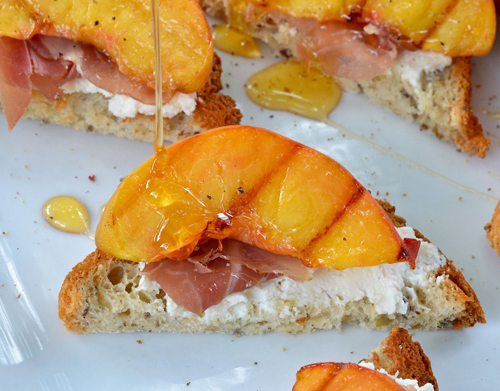 three bakers crostini with grilled peaches, prosciutto, goat cheese and honey
