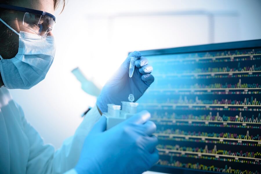 scientist with goggles looking at test tubes