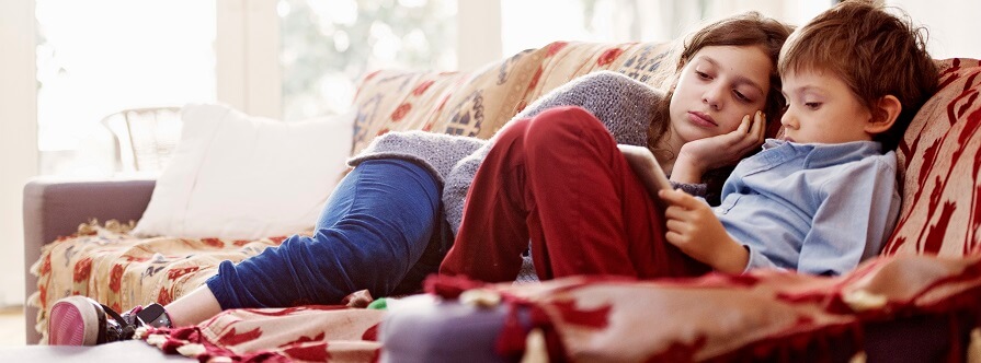 Siblings laying on couch 