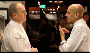 The two chefs are talking to each other.