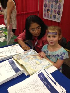 Ritu with a young child. They're looking at a book.