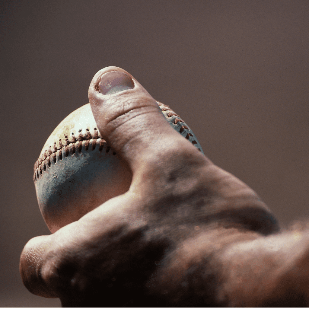 A hand holding a baseball