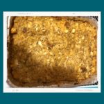 A pan of cornbread and chicken stuffing against a teal background.