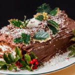 A chocolate yule log decorated with holly. 