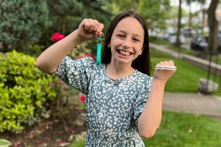A photo of Sophie holding up a keychain and bracelet.