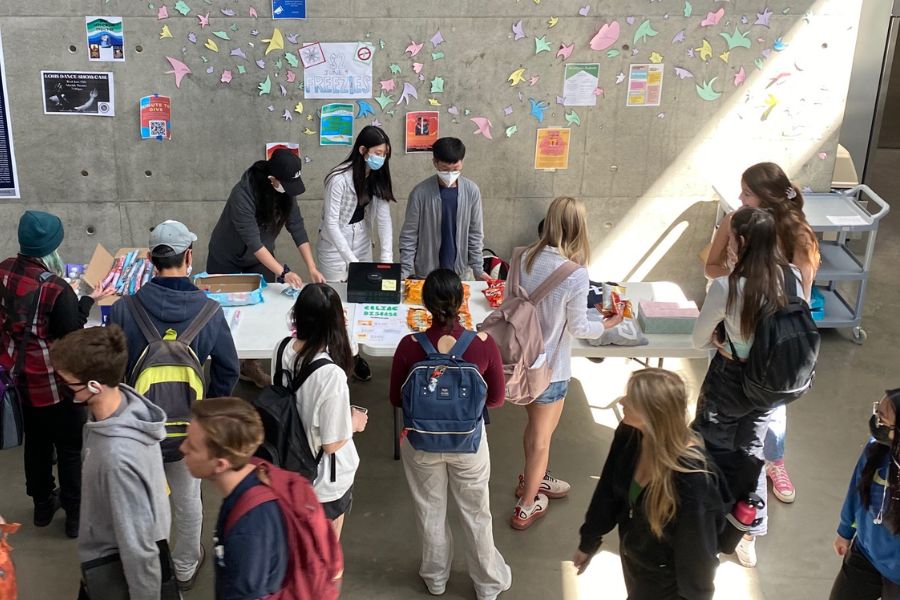 A group of students buying snacks from a table.