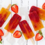 Fruit popsicles with slices strawberries.