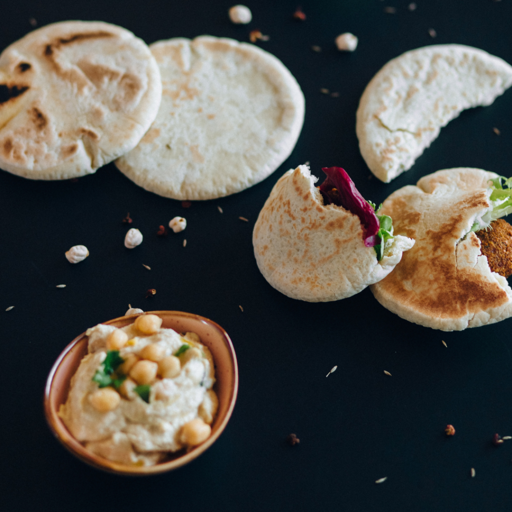 Pita and a bowl of hummus on a table.