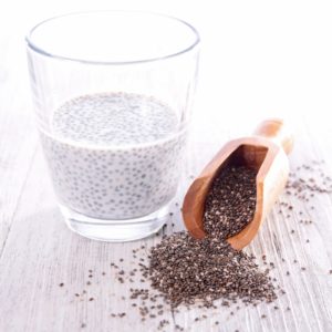A cup of wet chia seeds next to a scoop of dry chia seeds. 