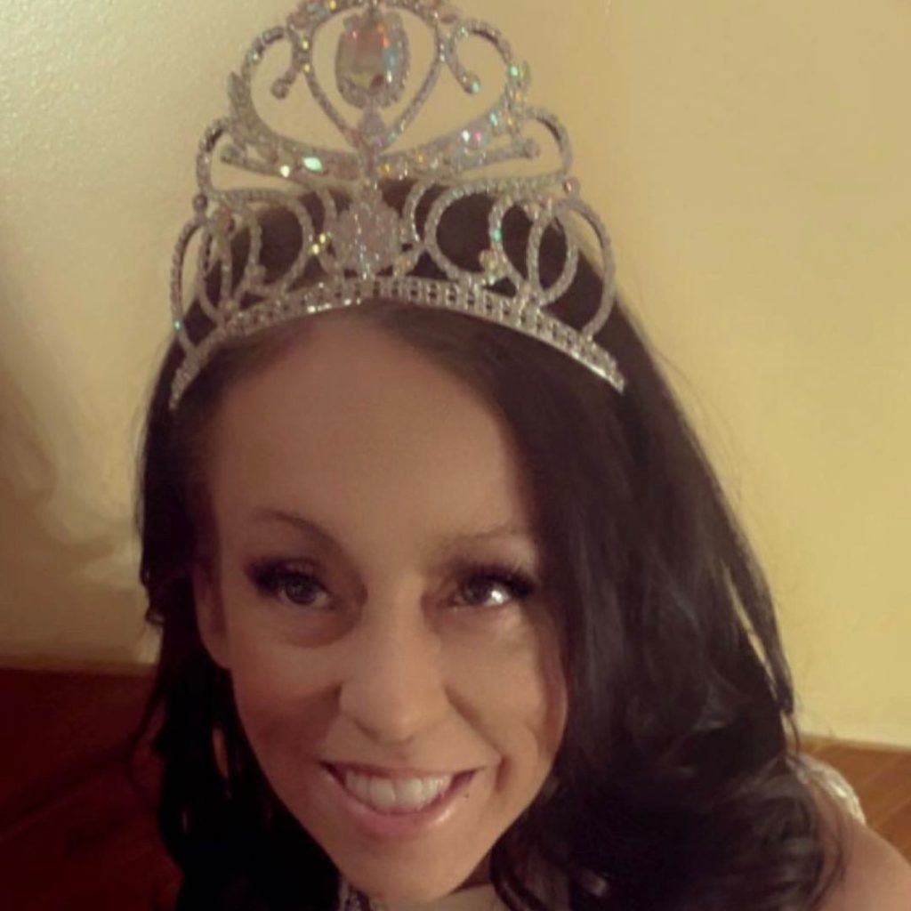 A photo of Nikki smiling and wearing a pageant crown.