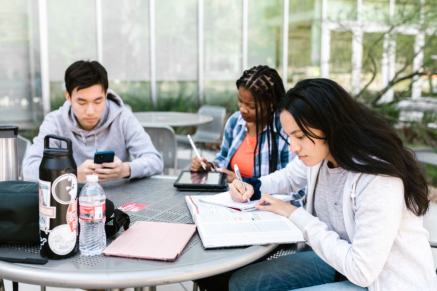 Three students studying outside.