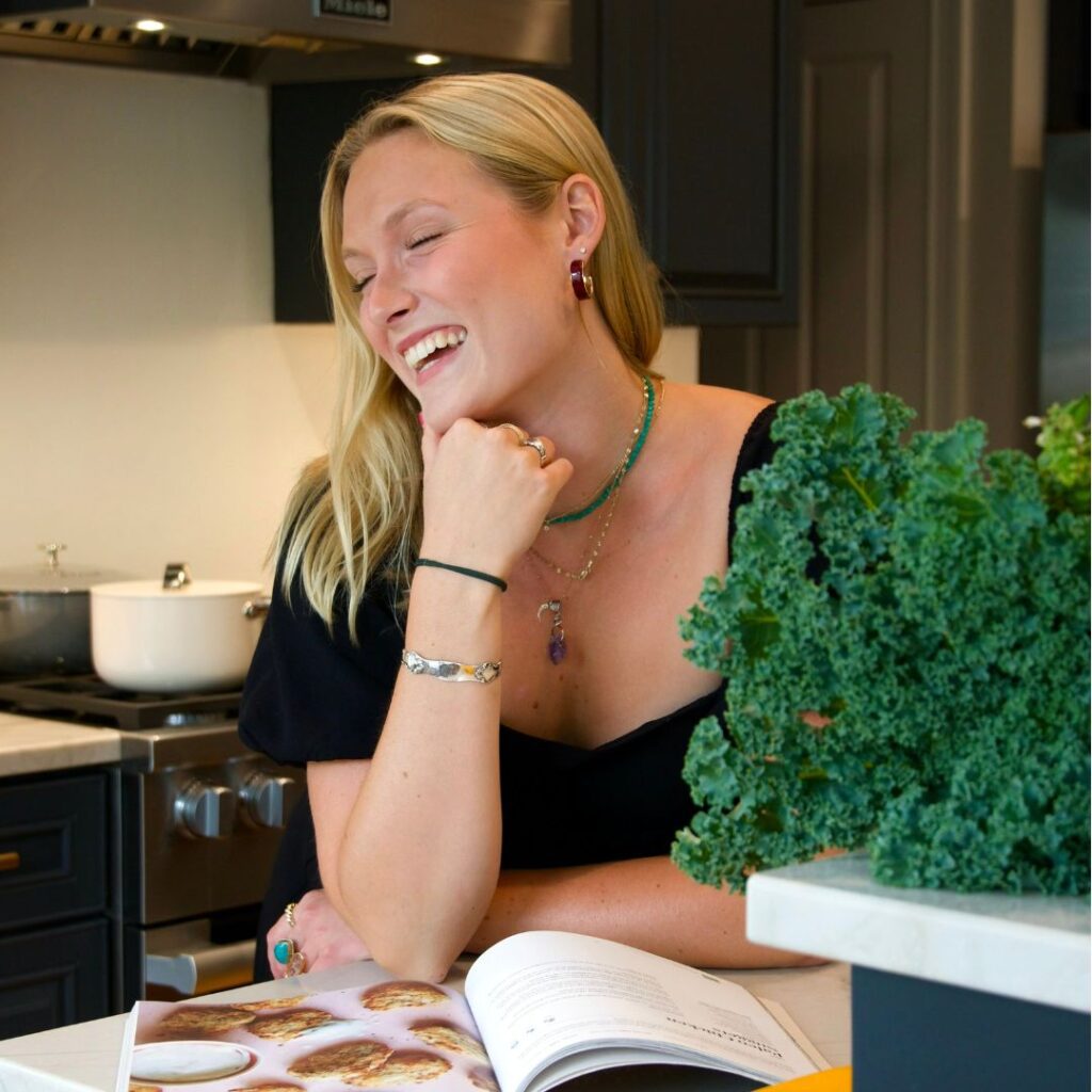 Lauren is smiling and reading a cookbook.