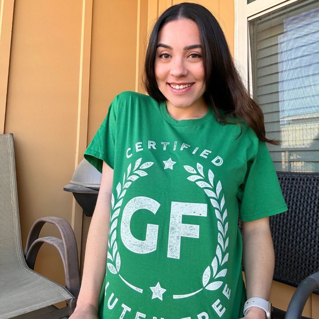 A photo of Emily smiling. She is wearing a shirt that says "Certified GF."