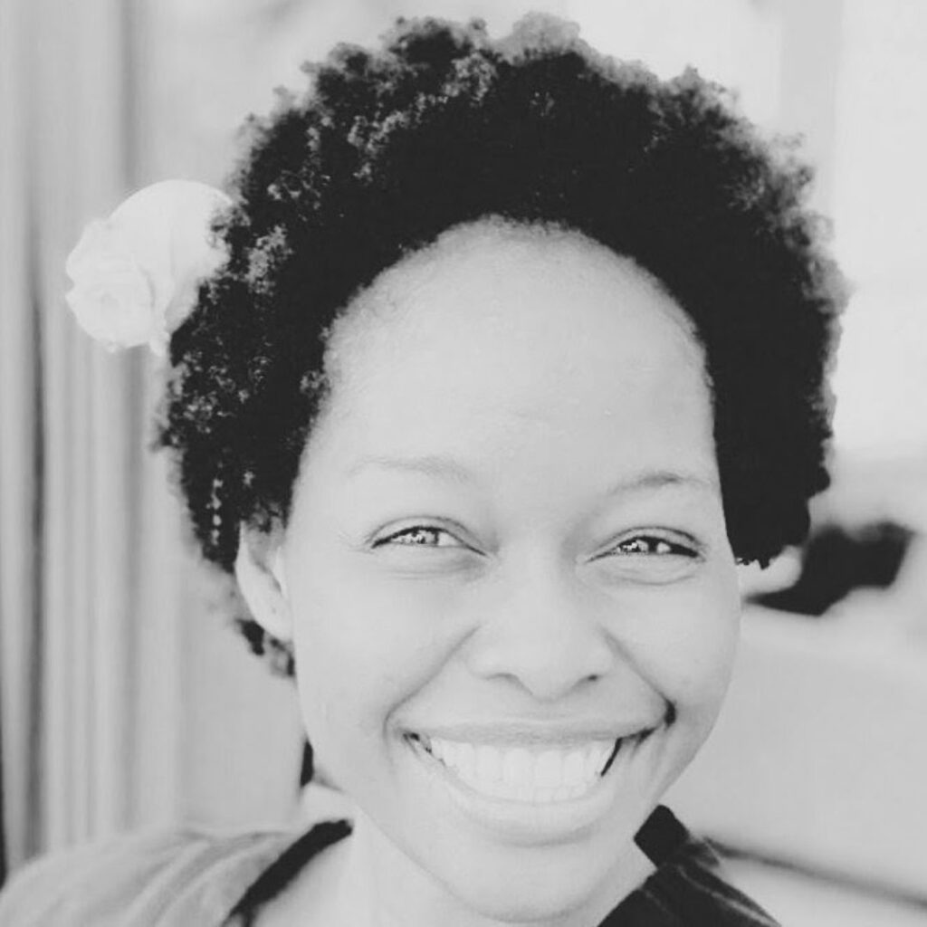 A black and white photo of Deborah smiling.