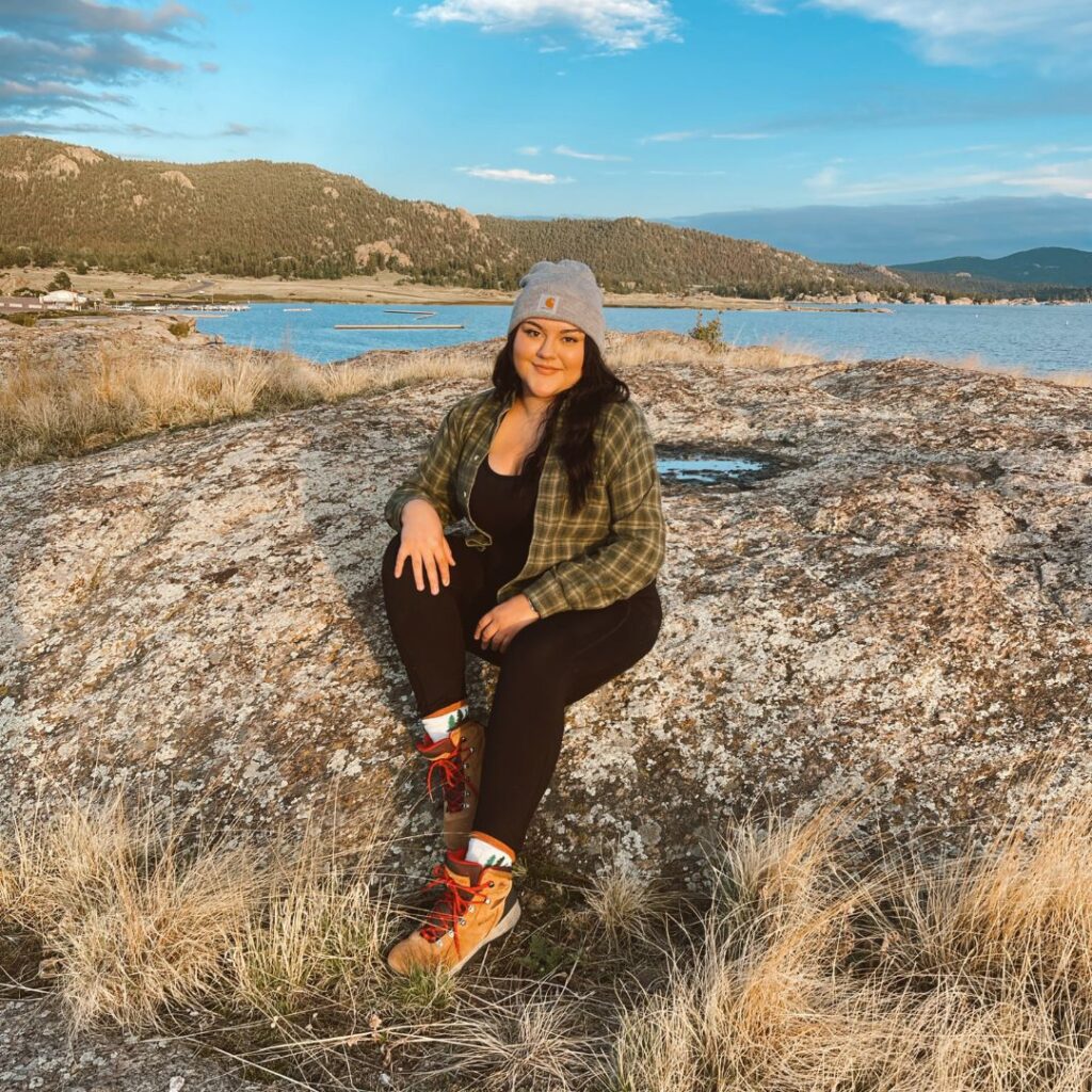 Brittany sitting in a field next to a lake