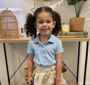 Photo of Katerina wearing a blue shirt and tan skirt.