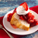 A slice of angel food cake with whipped cream and strawberries.
