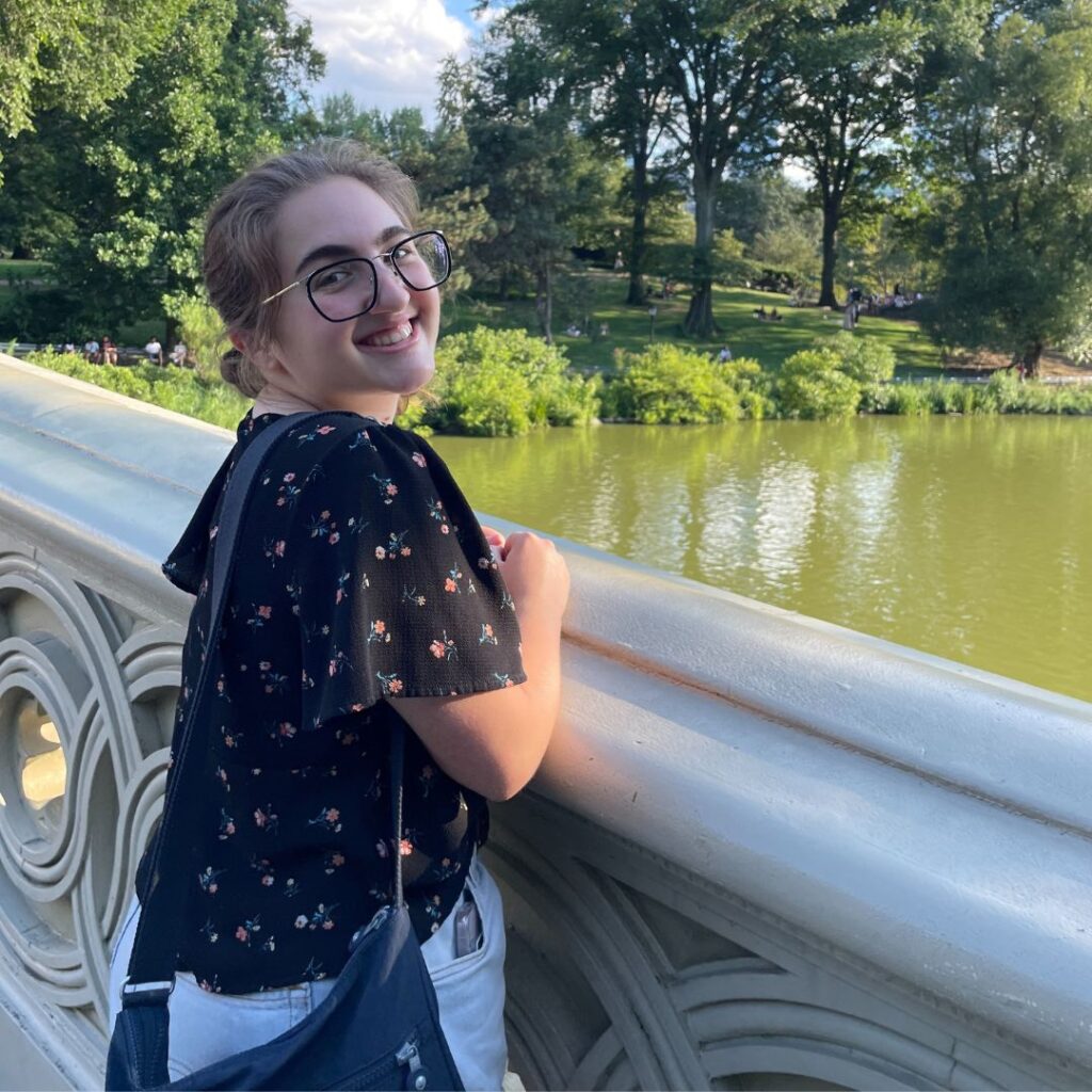 A photo of Ilana smiling on a bridge.
