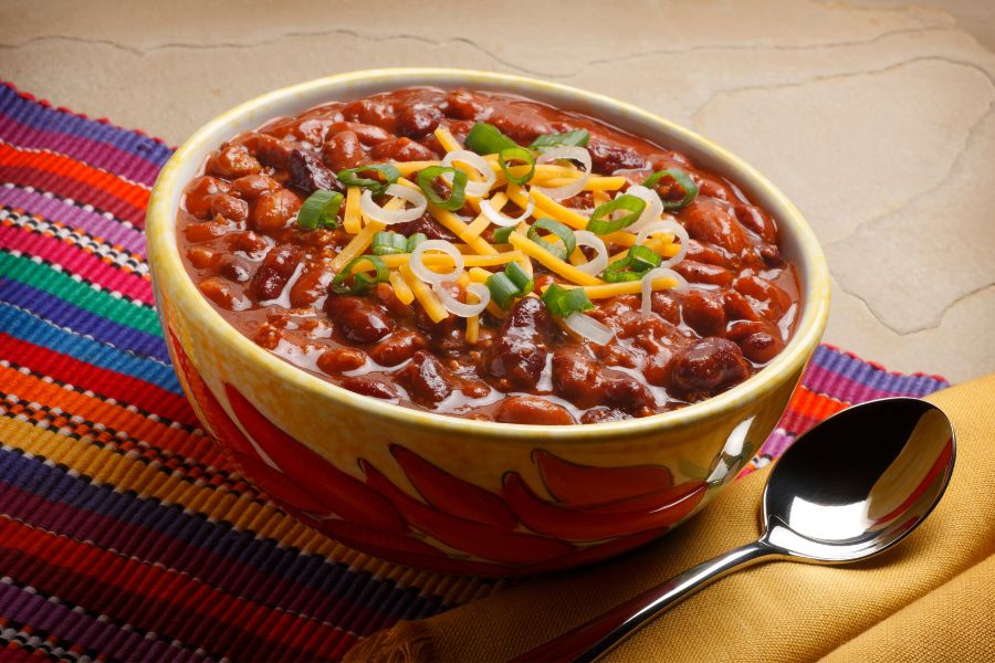 A bowl of chili on a colorful placemat.