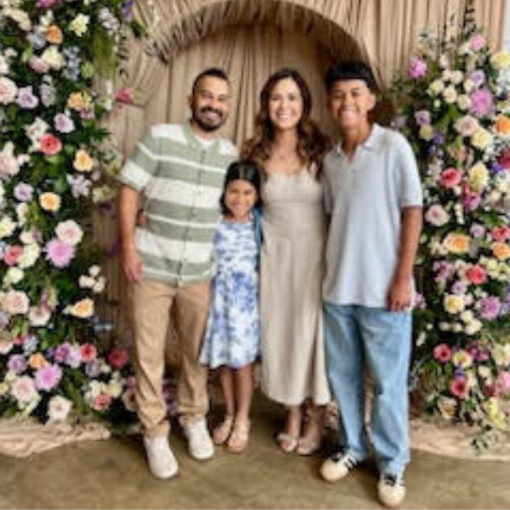 A photo of Zamira smiling with her family.