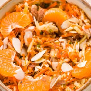 A close-up of coleslaw with an orange vinaigrette.