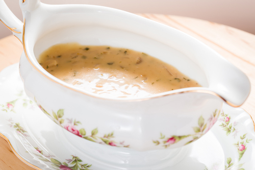 A serving bowl of apple cider gravy.