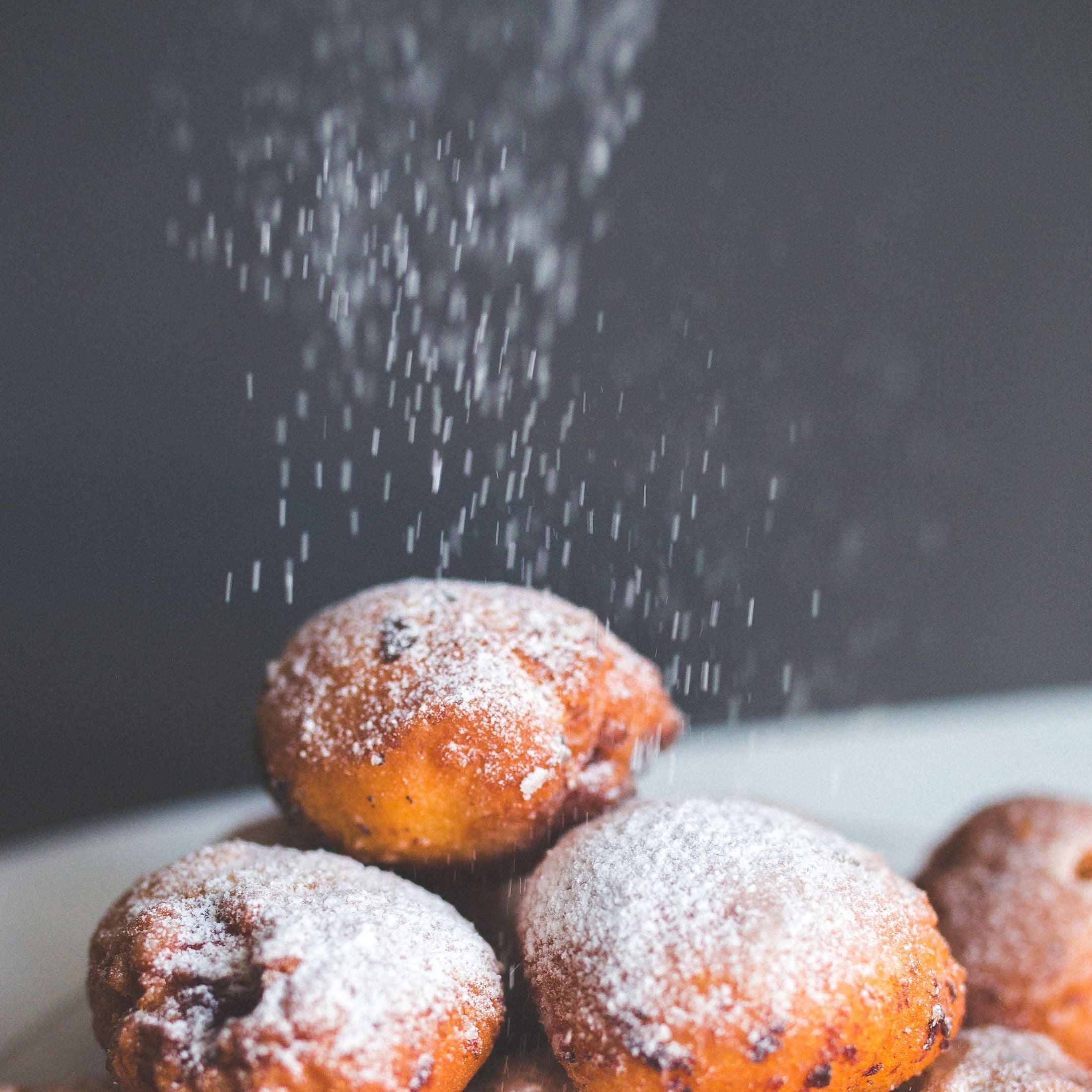 Sprinkling powdered sugar on pastries.