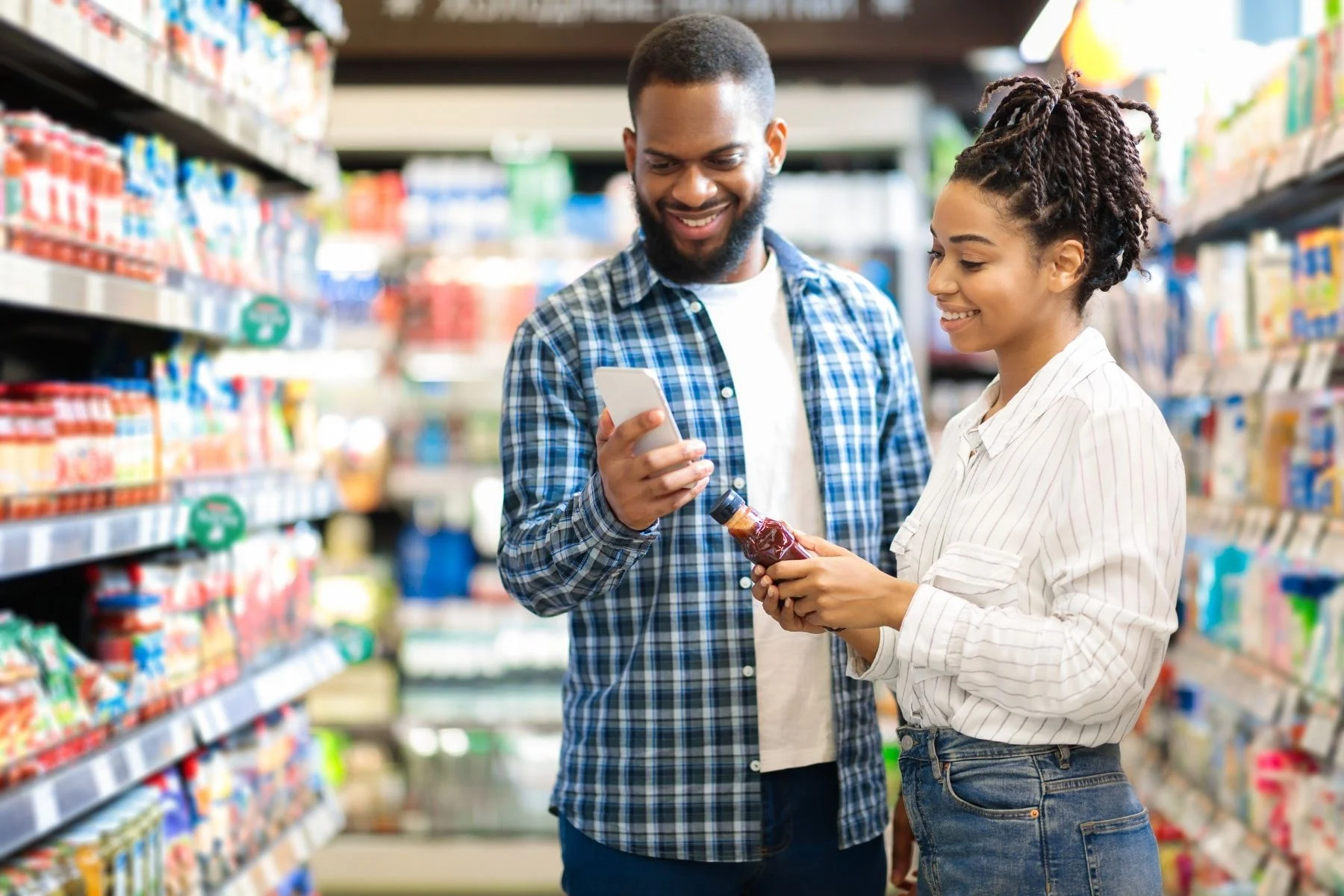 A smiling couple reading a food label.