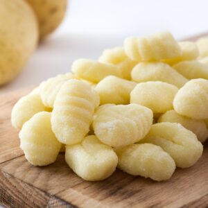 Pieces of gnocchi on a cutting board.